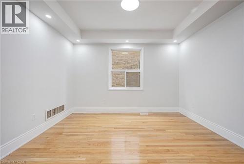 Bright interior room featuring wood-finish flooring, white baseboards, and a window with white trim - 5 Freshspring Drive, Brampton, ON - Indoor Photo Showing Other Room