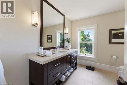 Vanity featuring a light-colored countertop, undermount sink, and dark wood-finish cabinetry - 8430 Road 146, Listowel, ON - Indoor Photo Showing Bathroom