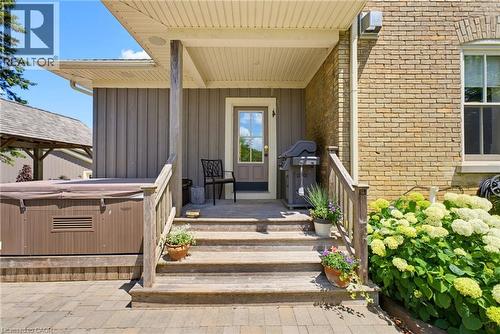 Covered porch entry featuring wood-finish steps and railing - 8430 Road 146, Listowel, ON - Outdoor With Deck Patio Veranda With Exterior