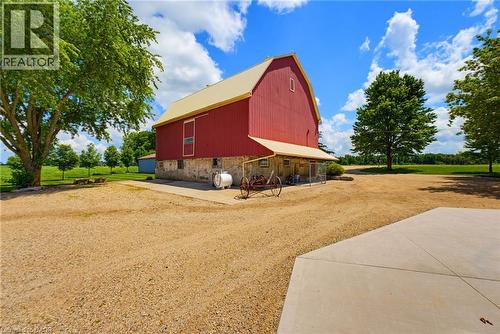 Classic red barn structure featuring a stone foundation and a light-colored roof - 8430 Road 146, Listowel, ON - Outdoor