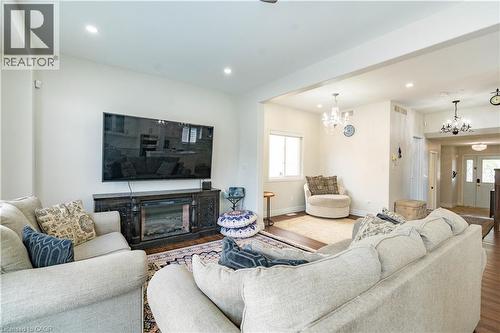 Spacious living area featuring wood-finish flooring, recessed lighting, and a decorative fireplace unit - 122 Iron Gate Street, Kitchener, ON - Indoor Photo Showing Living Room With Fireplace