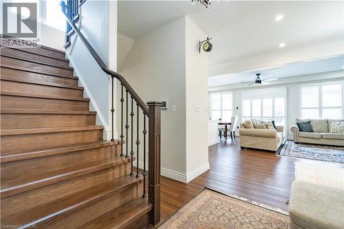 Hardwood staircase with wrought iron balusters and a dark wood handrail - 122 Iron Gate Street, Kitchener, ON - Indoor Photo Showing Other Room