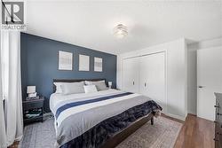 Bedroom featuring a rich blue accent wall and recessed lighting - 