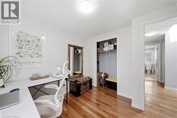 Room featuring wood-finish flooring, a built-in closet, and a neutral wall color - 