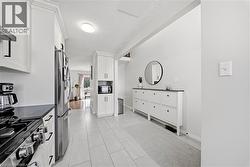 Gourmet kitchen with stainless steel appliances, white cabinetry, dark countertops, and tile flooring - 