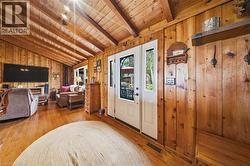 Vaulted wood-paneled ceiling with exposed beams, wood-plank flooring, and wood-paneled walls - 