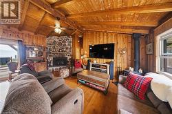 Wood-paneled living area featuring a vaulted wood ceiling with exposed beams - 