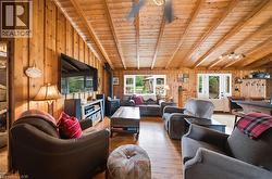 Spacious living area featuring extensive wood paneling and wood-finish flooring - 