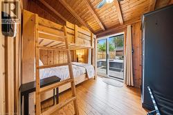Room featuring wood-plank walls and ceiling with exposed beams - 