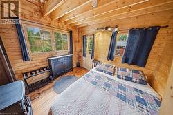 Wood-paneled interior featuring exposed ceiling beams and wood-finish flooring - 