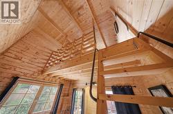 Wood-paneled interior featuring a lofted space and an angled ceiling - 