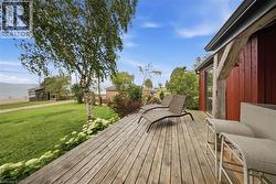 Spacious wood-plank deck with a red exterior structure - 
