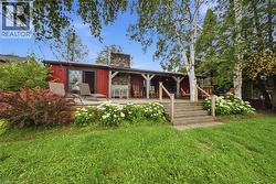 Red exterior with a stone chimney and a covered porch - 