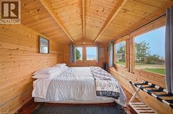 Interior space with extensive natural wood paneling, sloped wood-finish ceiling, and multiple windows - 