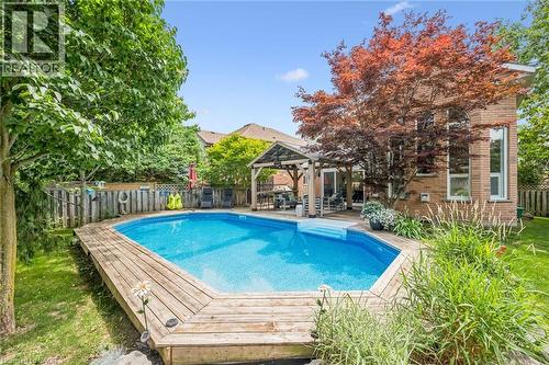 Backyard oasis featuring an in-ground swimming pool with wood-finish decking - 916 Rush Meadow Court, Kitchener, ON - Outdoor