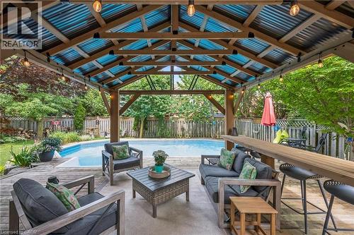 Covered patio featuring a wood-frame and corrugated roof structure - 916 Rush Meadow Court, Kitchener, ON - Outdoor With In Ground Pool With Deck Patio Veranda