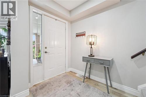 Entryway featuring a solid panel door with a sidelight, wood-finish flooring, and a built-in stair railing - 916 Rush Meadow Court, Kitchener, ON - Indoor Photo Showing Other Room