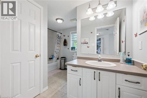 Bathroom featuring a vanity with an integrated sink, a large mirror, and a wall-mounted light fixture - 916 Rush Meadow Court, Kitchener, ON - Indoor Photo Showing Bathroom