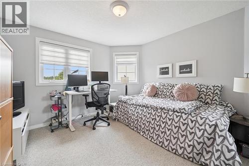 Carpeted room featuring light gray walls, white trim, two windows with horizontal blinds, and an overhead flush-mount light fixture - 916 Rush Meadow Court, Kitchener, ON - Indoor Photo Showing Bedroom
