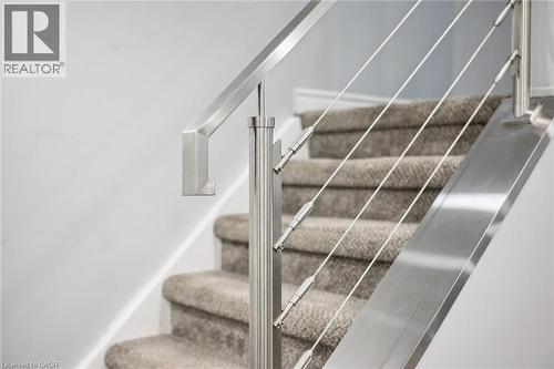Modern cable railing system with a brushed metal handrail and posts - 916 Rush Meadow Court, Kitchener, ON - Indoor Photo Showing Other Room