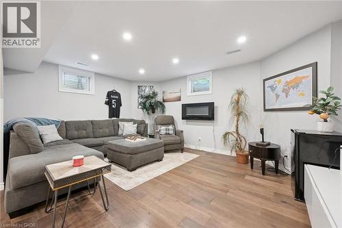 Spacious finished basement with wood-finish flooring, recessed lighting, and light grey walls - 916 Rush Meadow Court, Kitchener, ON - Indoor