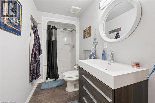 Bathroom featuring a contemporary vanity with an integrated sink, a white framed circular mirror, and a shower-tub combination - 916 Rush Meadow Court, Kitchener, ON - Indoor Photo Showing Bathroom