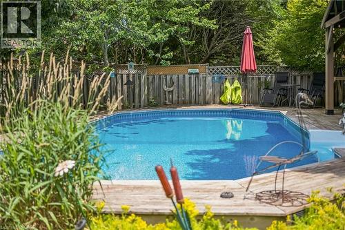 Swimming pool with integrated steps set within a wood-finish deck - 916 Rush Meadow Court, Kitchener, ON - Outdoor With In Ground Pool
