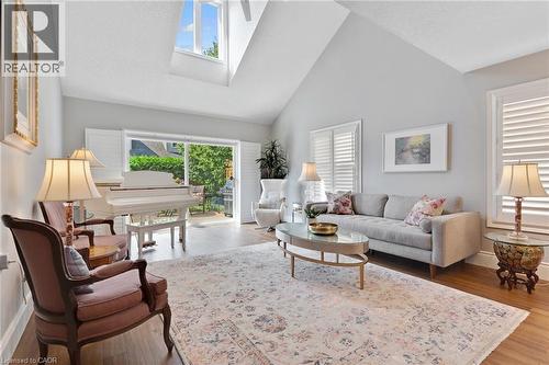 Living space featuring vaulted ceilings with skylight, wood-finish flooring, sliding glass doors, and white plantation shutters - 350 Doon Valley Drive Unit# 6D, Kitchener, ON - Indoor Photo Showing Living Room
