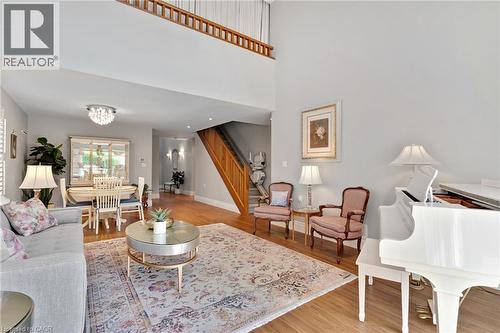 Two-story living area featuring wood-finish flooring and a second-level open railing - 350 Doon Valley Drive Unit# 6D, Kitchener, ON - Indoor Photo Showing Living Room