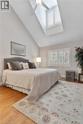 Vaulted ceiling with skylight and ceiling fan, wood-finish flooring, and window with plantation shutters - 350 Doon Valley Drive Unit# 6D, Kitchener, ON - Indoor Photo Showing Bedroom