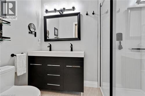 Contemporary bathroom featuring a double vanity with integrated sinks, black wood-finish cabinetry, and chrome hardware - 350 Doon Valley Drive Unit# 6D, Kitchener, ON - Indoor Photo Showing Bathroom