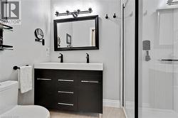 Contemporary bathroom featuring a double vanity with integrated sinks, black wood-finish cabinetry, and chrome hardware - 