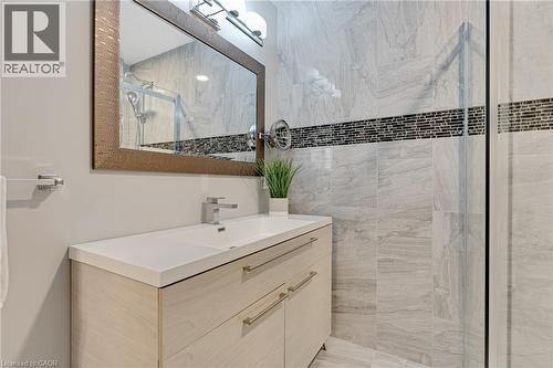 Spacious bathroom featuring a light wood-finish vanity with a single basin sink, white countertop, and contemporary faucet - 350 Doon Valley Drive Unit# 6D, Kitchener, ON - Indoor Photo Showing Bathroom