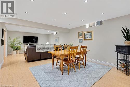 Open-concept recreation area featuring wood-finish flooring, recessed lighting, and a light gray area rug - 350 Doon Valley Drive Unit# 6D, Kitchener, ON - Indoor