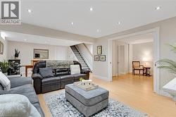 Open-concept living area featuring light wood-finish flooring, recessed lighting, and neutral wall tones - 