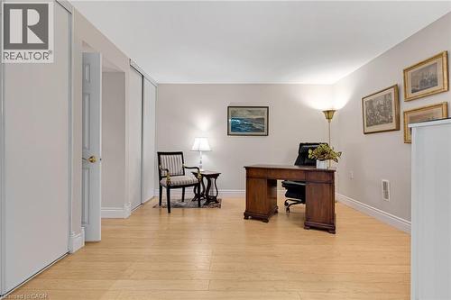 Spacious room featuring light wood-finish flooring, light-toned walls, white trim, and a built-in wall closet - 350 Doon Valley Drive Unit# 6D, Kitchener, ON - Indoor Photo Showing Other Room