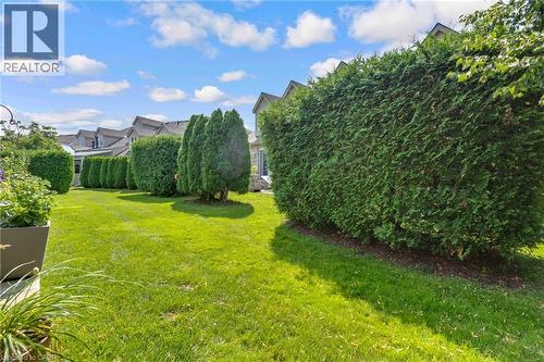 Expansive lawn area featuring well-maintained hedges and mature trees - 350 Doon Valley Drive Unit# 6D, Kitchener, ON - Outdoor