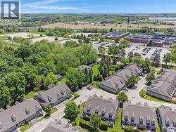 Aerial overview featuring a residential community with townhomes and detached properties - 