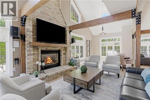Expansive living area featuring a floor-to-ceiling brick fireplace with a wood mantel - 350 Doon Valley Drive Unit# 6D, Kitchener, ON - Indoor Photo Showing Living Room With Fireplace