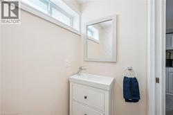 Vanity with integrated sink and chrome faucet, framed mirror, and upper transom window - 