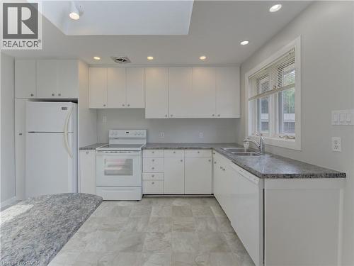 Kitchen featuring white cabinetry, grey granite-style countertops, double basin sink, and recessed lighting - 139 Trafalgar Avenue, Kitchener, ON - Indoor Photo Showing Kitchen With Double Sink