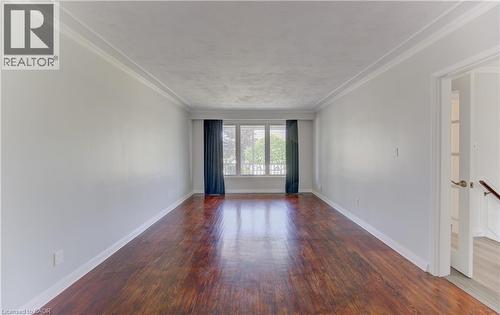 Spacious room featuring hardwood flooring, white walls, and a large front window - 139 Trafalgar Avenue, Kitchener, ON - Indoor Photo Showing Other Room