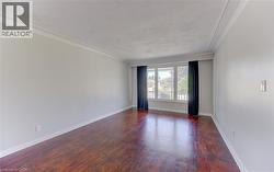 Spacious interior featuring rich hardwoodflooring, light gray wall tones, and white crown molding - 