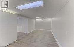 Spacious interior room that can double as another 4th bedroom, Den or Office featuring light wood-finish flooring, white walls, and bright overhead lighting - 