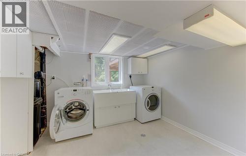 Dedicated laundry room featuring light-toned flooring, a utility sink, and a window - 139 Trafalgar Avenue, Kitchener, ON - Indoor Photo Showing Laundry Room