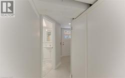 Interior corridor leading to bathroom and walkout to back patio with light gray walls, white trim, and light flooring - 