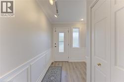 Entryway featuring a panel door with frosted glass, side window, and wood-finish flooring - 