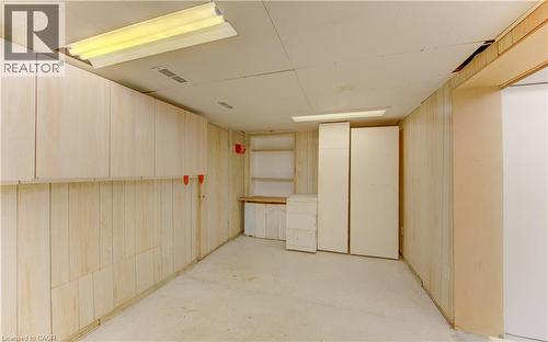 Utility room featuring extensive wood-paneled walls and a concrete floor - 139 Trafalgar Avenue, Kitchener, ON - Indoor Photo Showing Other Room
