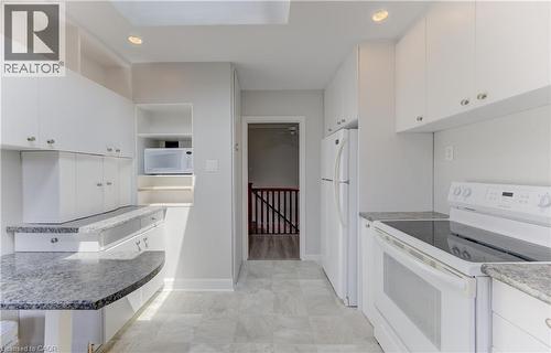 Kitchen featuring white cabinetry, gray patterned countertops, and a white electric range - 139 Trafalgar Avenue, Kitchener, ON - Indoor Photo Showing Kitchen