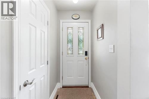 Entryway featuring a white door with decorative glass inserts, a smart lock, and light gray wall paint - 1063 Joan Drive, Burlington, ON - Indoor Photo Showing Other Room